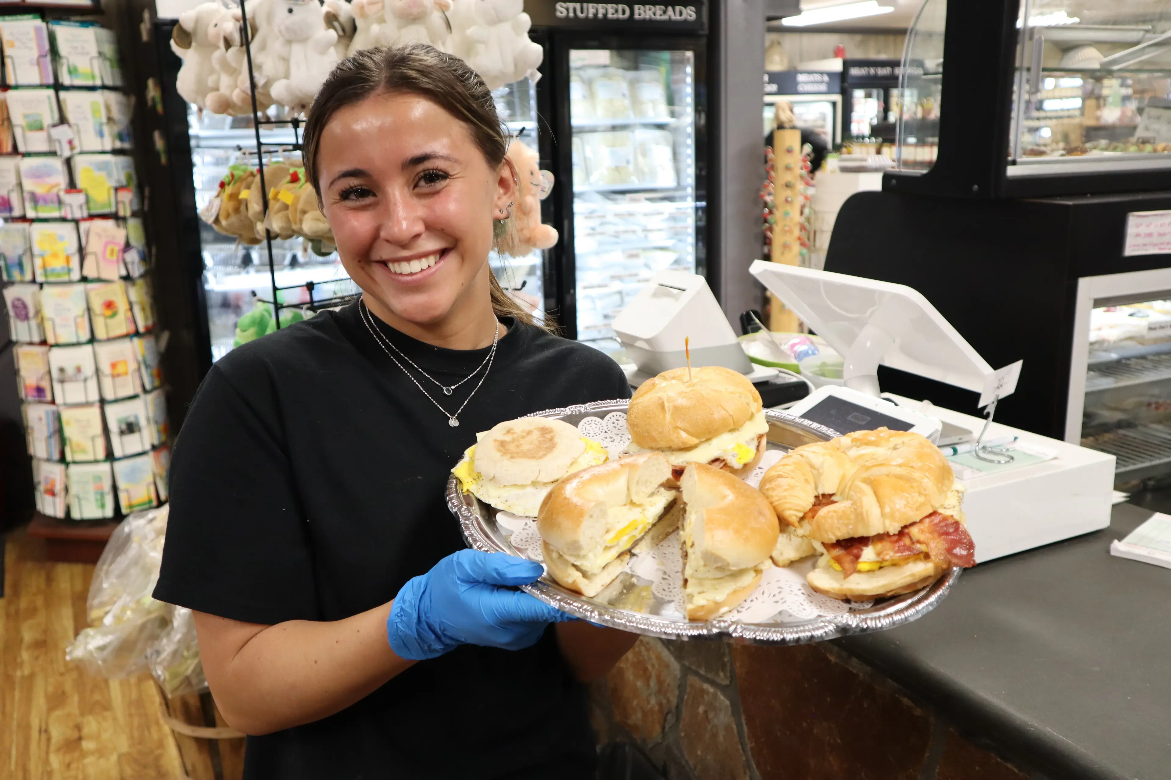 Tray of breakfast sandwiches on rolls, English muffins and croissants held at the counter
